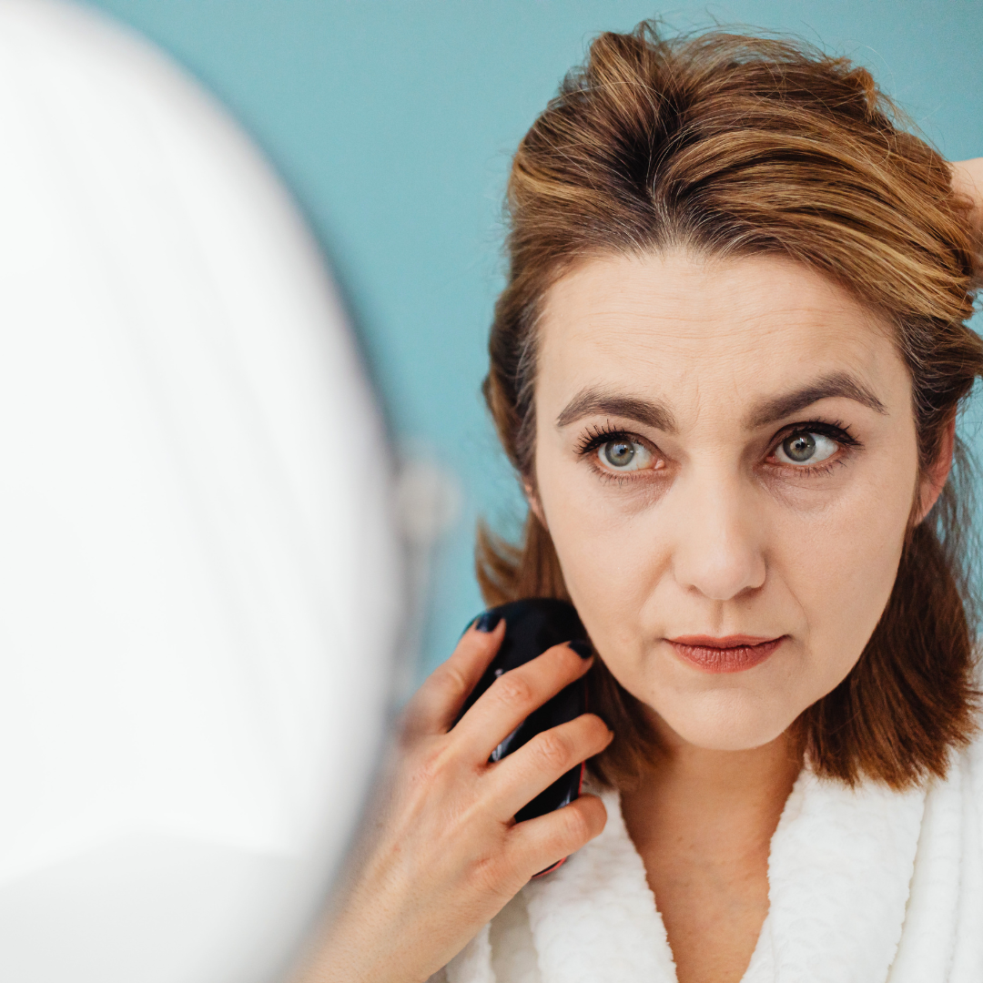 woman looking at winter skin damage in mirror